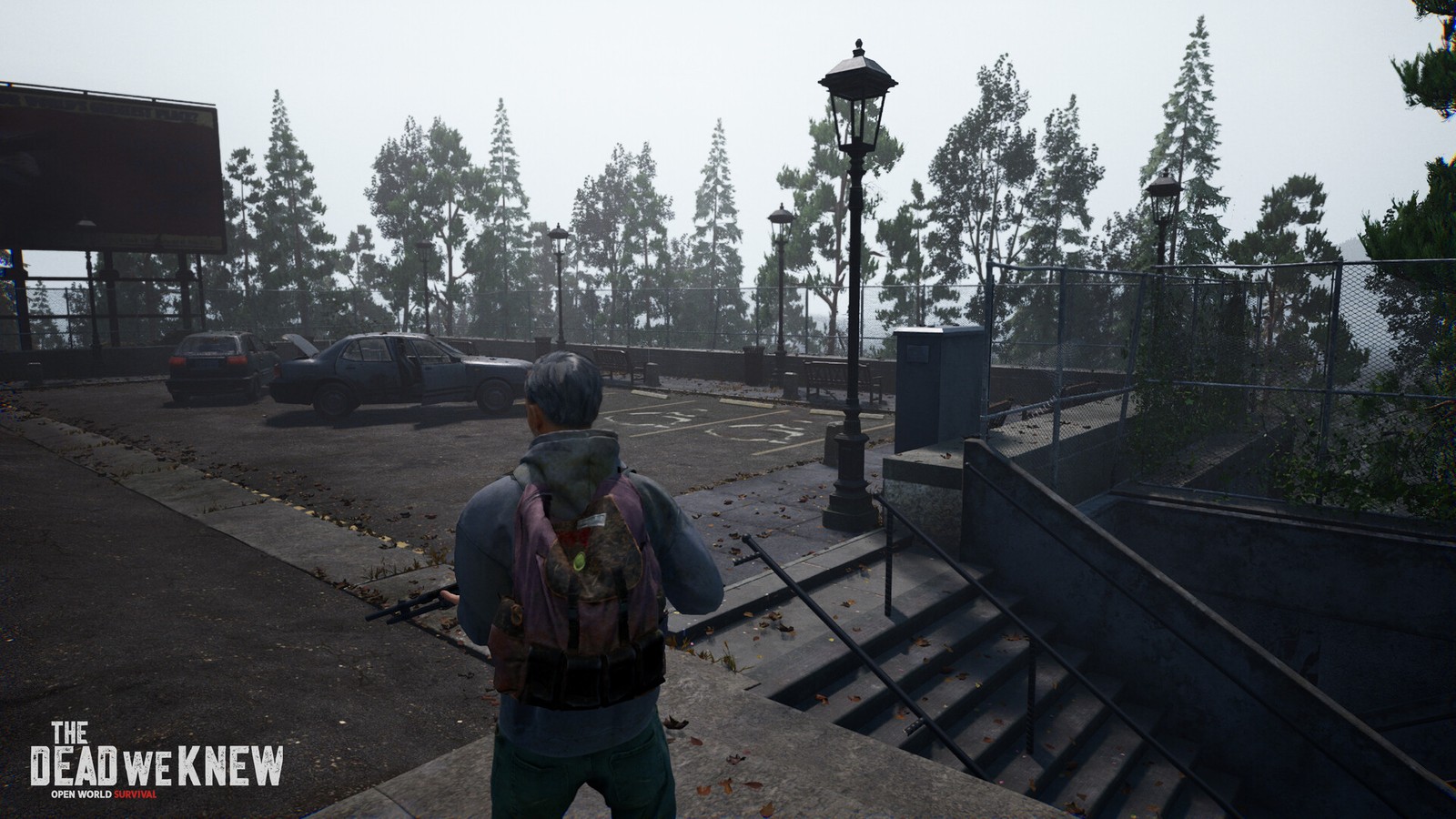 Foggy overlook parking area with abandoned cars and billboard